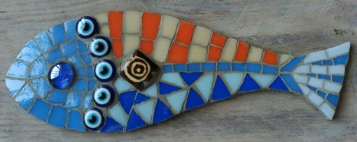 Mosaico de un pez de colores en tonos azueles y naranjas sobre una madera reciclada.